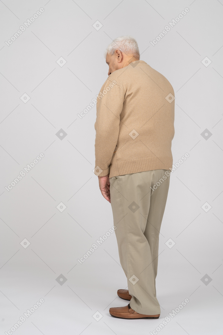 Vista traseira de um velho em roupas casuais, olhando para baixo