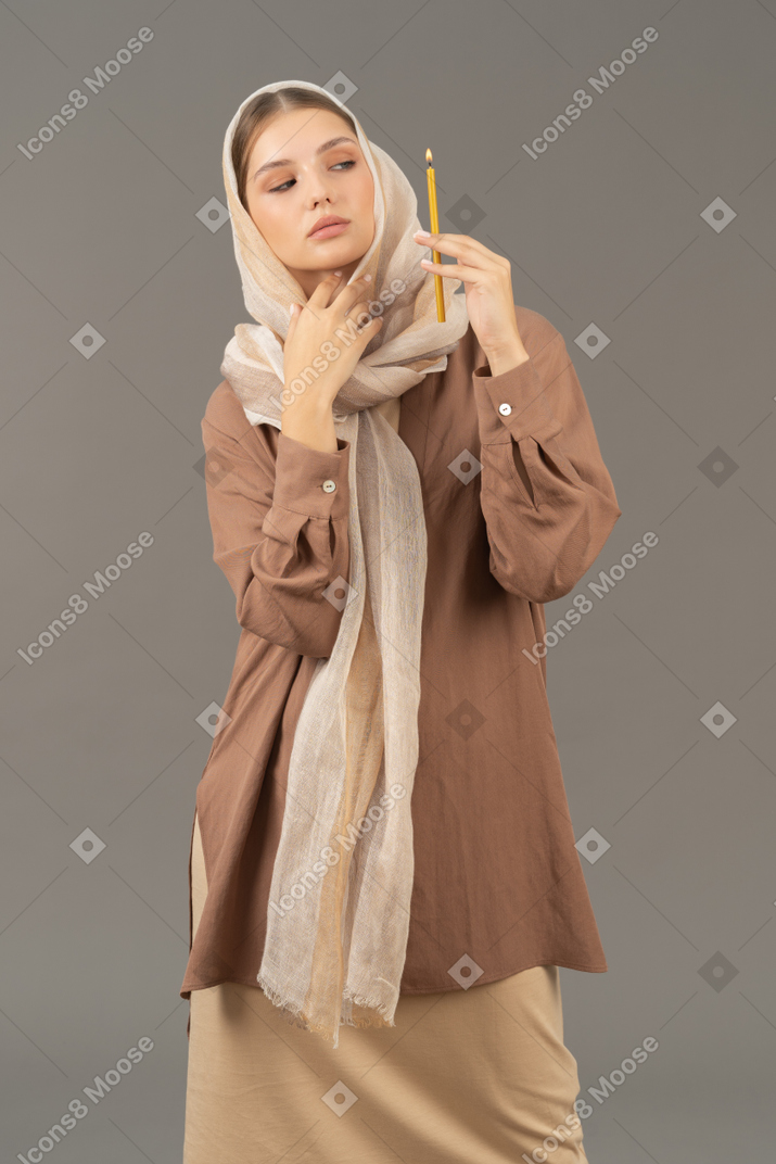 Femme religieuse posant avec une bougie