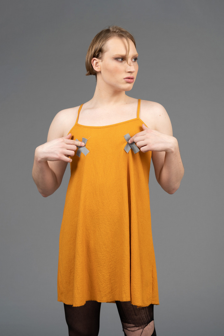 Portrait of a person in orange dress touching chest
