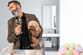 A man holding a glass of wine and a dog