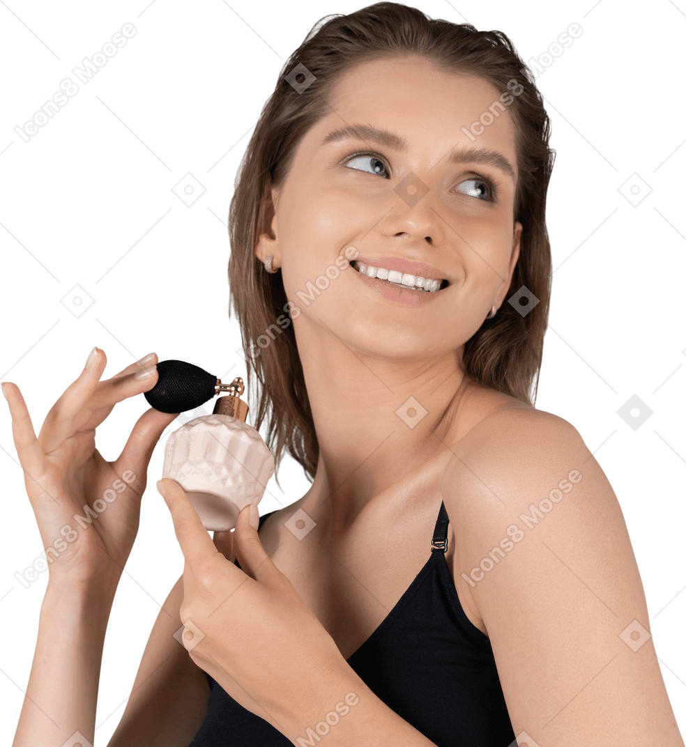 Vista de tres cuartos de una mujer joven sosteniendo una botella de perfume