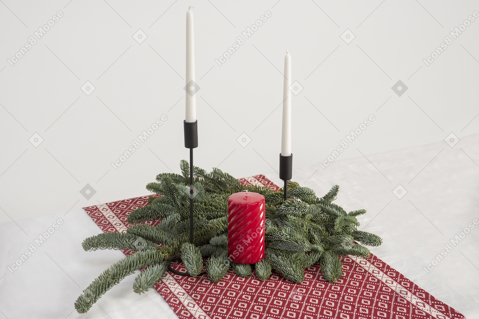 Vela grande y dos velas en candelabros y rama de árbol de navidad