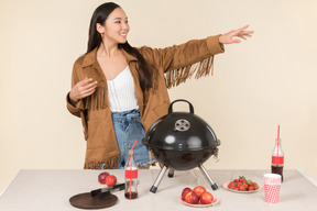 Young asian woman standing near closed grill