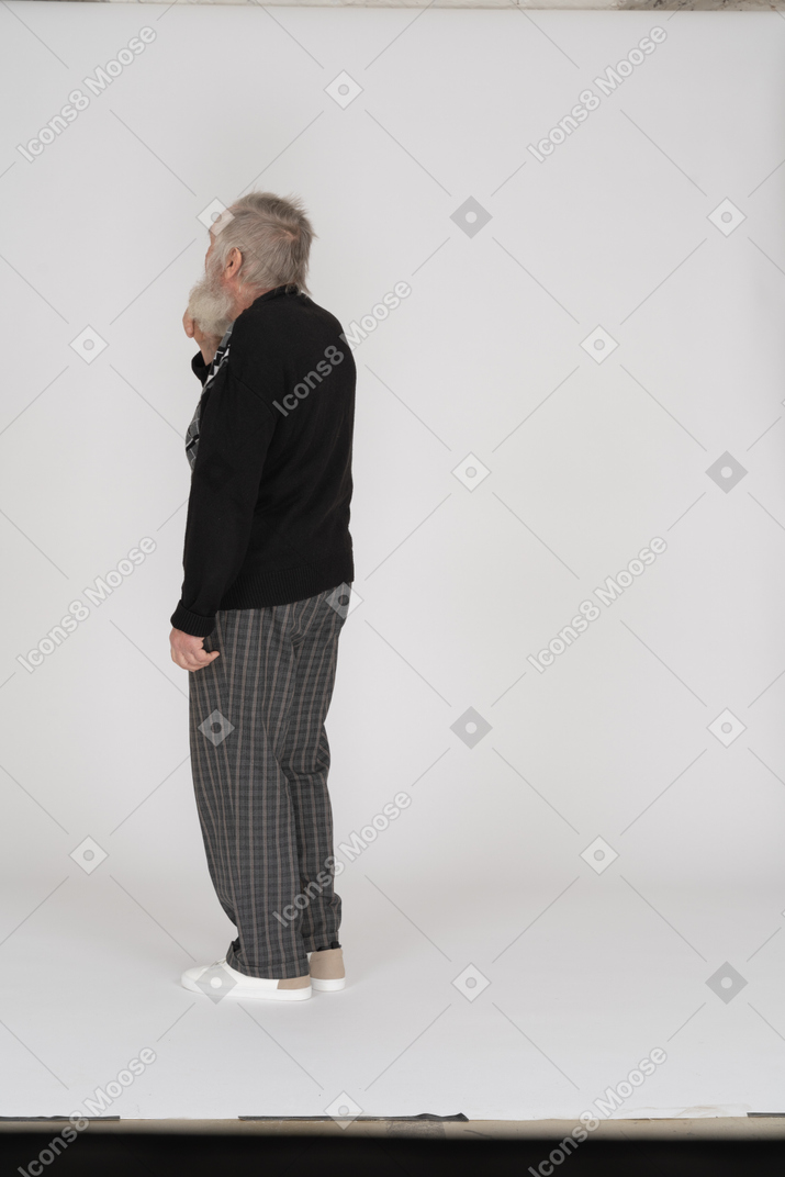 Three quarter back view of old man standing
