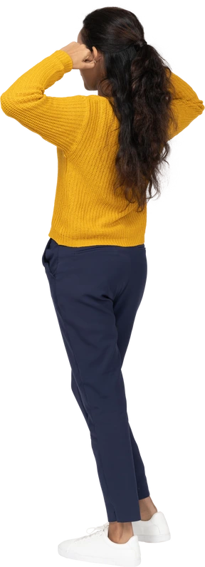 Rear view of a girl in casual clothes touching ears