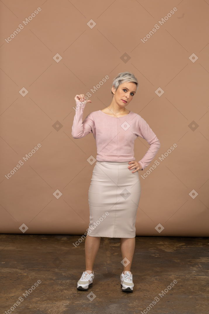 Vista frontal de uma mulher com roupas casuais apontando com o dedo
