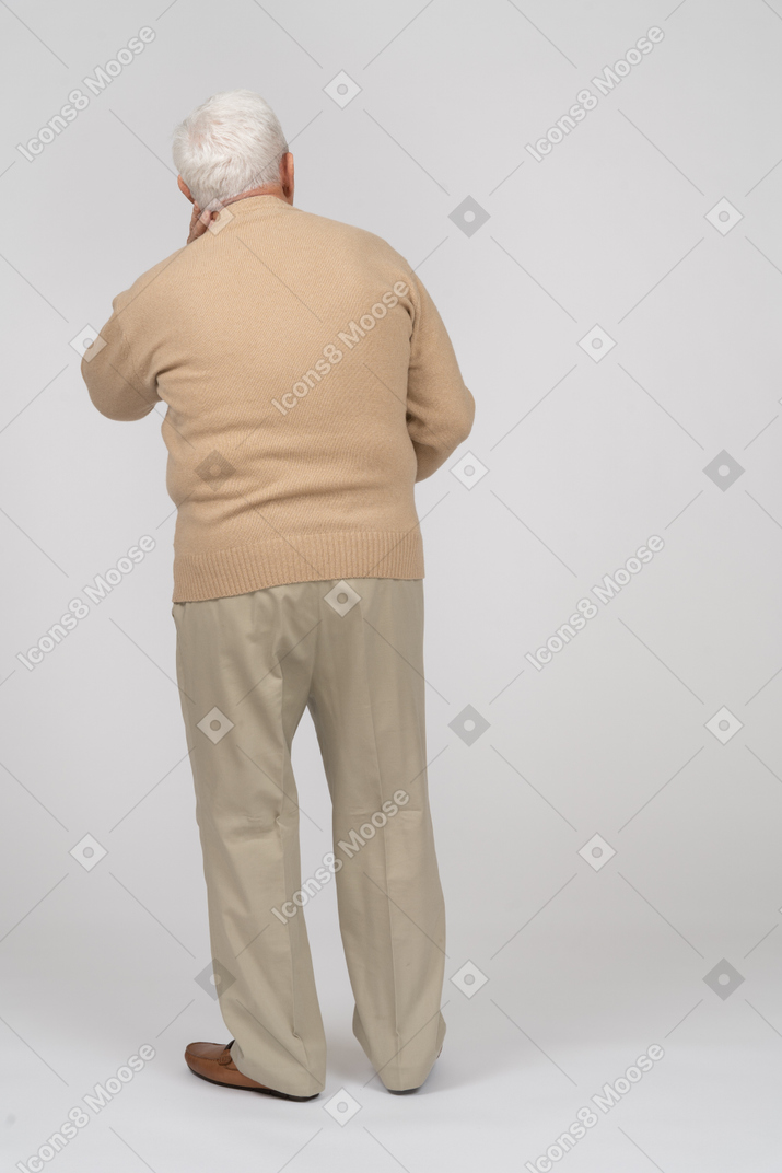 Vista traseira de um velho em roupas casuais, olhando para cima
