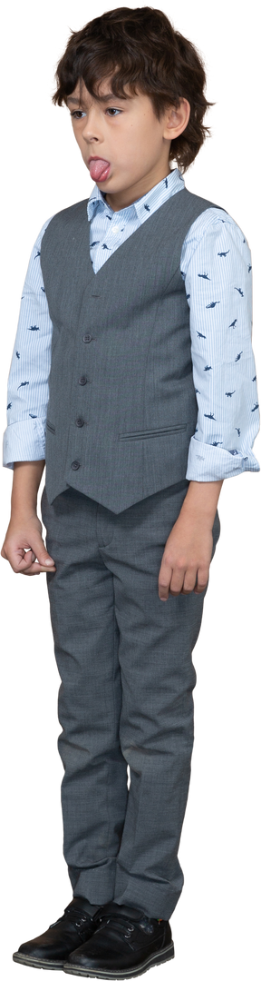Vista frontale di un ragazzo carino in abito grigio che mostra la lingua