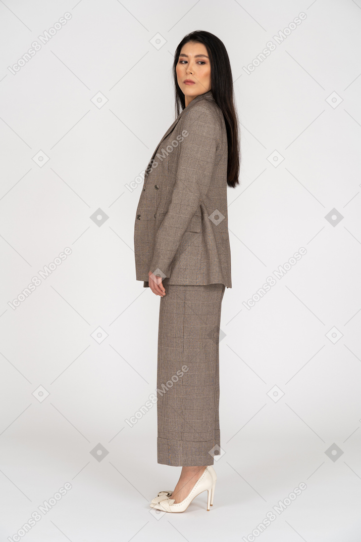 Side view of a young lady in brown business suit looking aside