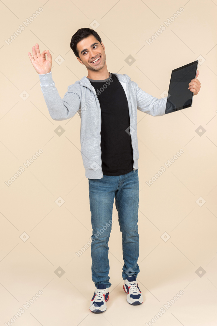 Giovane uomo caucasico in possesso di una tavoletta digitale