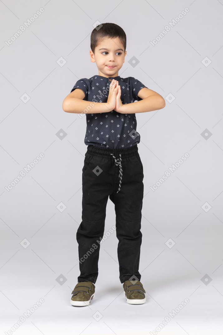 Vista frontale di un ragazzo carino che fa un gesto di preghiera