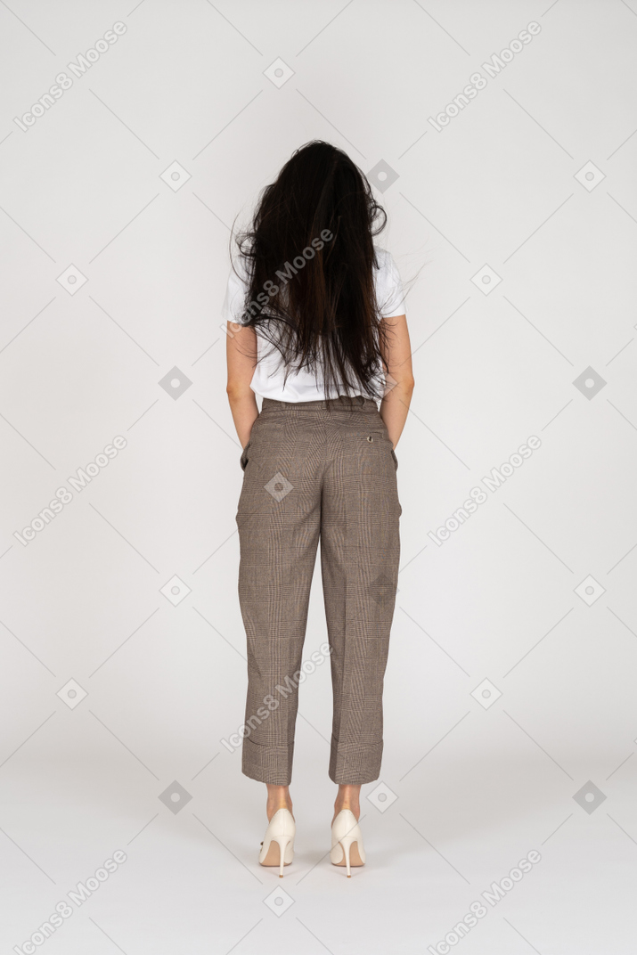 Vista de trás de uma jovem de calça e camiseta com cabelo bagunçado