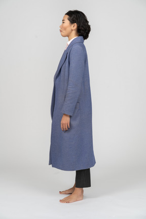 Vista lateral de uma mulher de casaco com bochechas sugadas