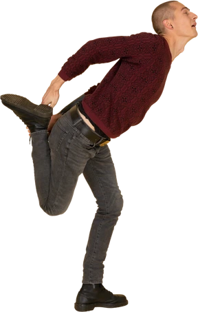 Side view of a young man in red pullover stretching his leg