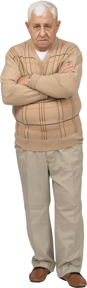 Vue de face d'un vieil homme en vêtements décontractés debout avec les bras croisés et regardant la caméra