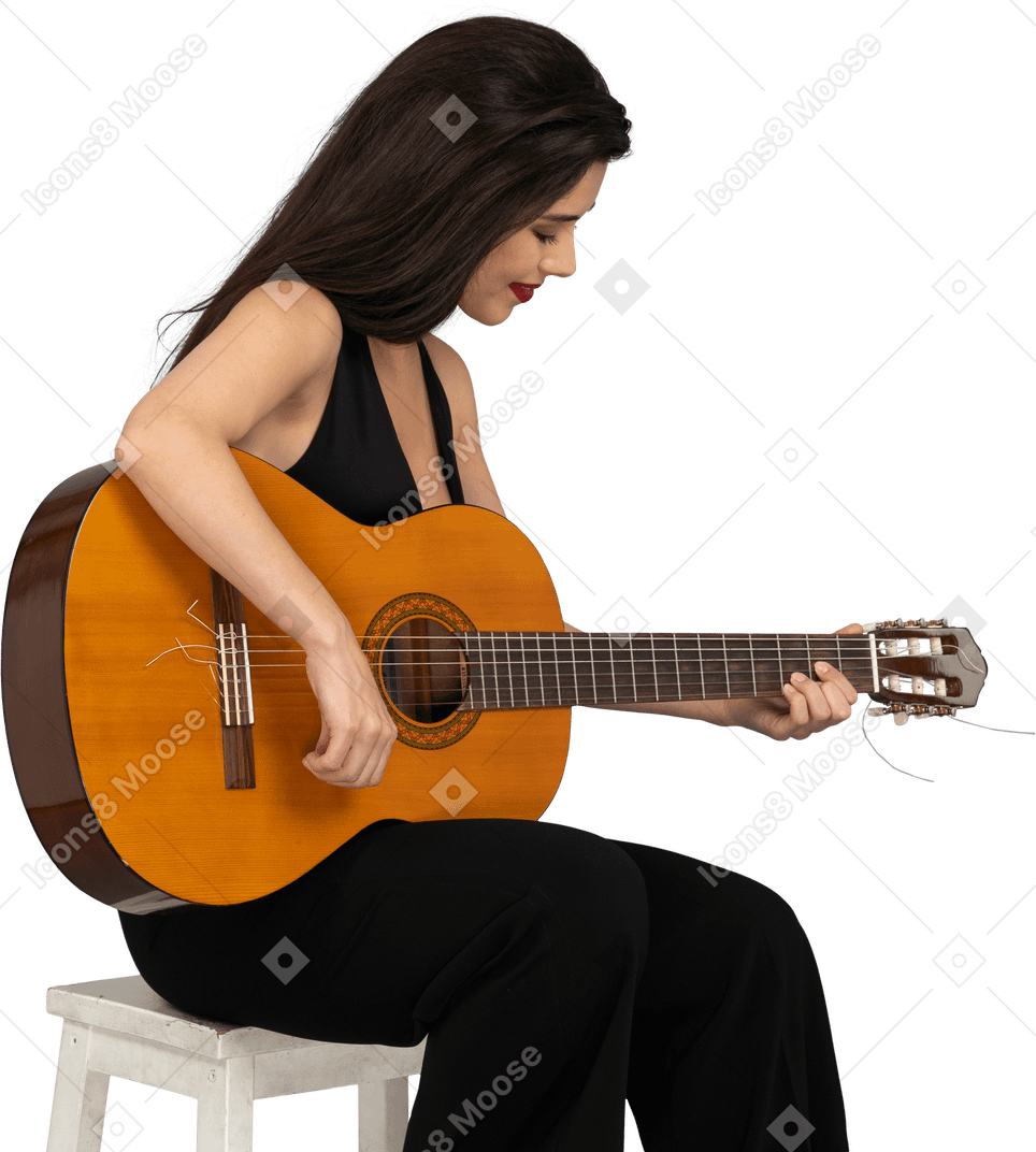 坐着的年轻女士，穿着黑色西装，弹吉他，往下看的四分之三视图
