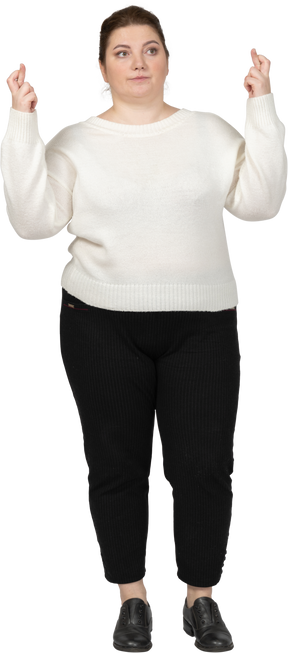 Vista frontal de uma mulher gorda em roupas casuais cruzando os dedos