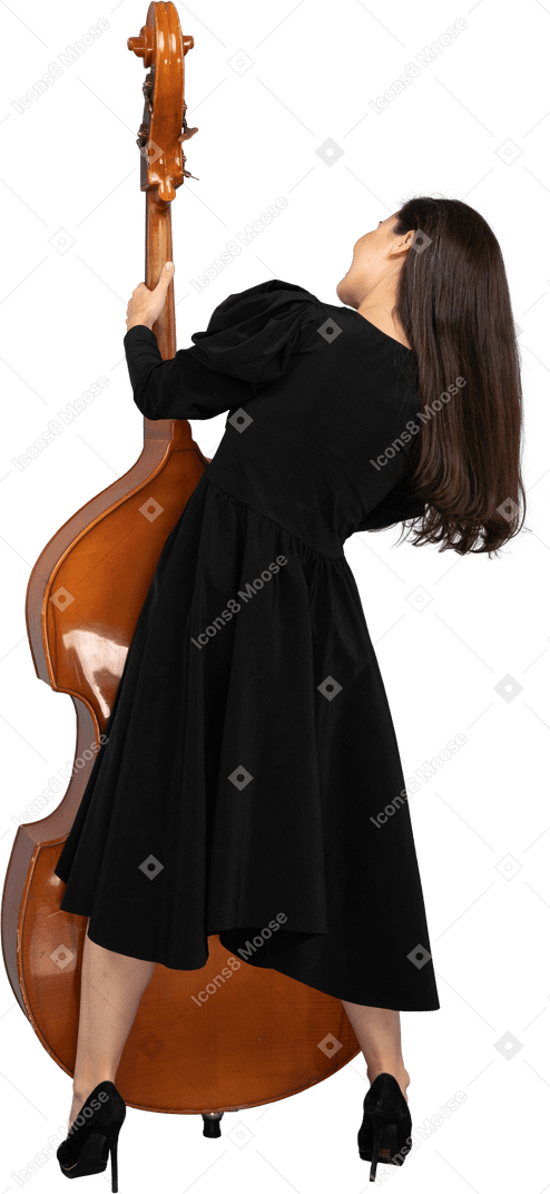 后面的观点的一位年轻的女音乐家，穿着黑色的连衣裙，抱着她的双低音