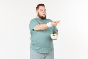 Big guy in sportswear handling salad leaves