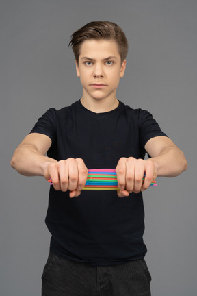 Male model holding tight a pile of plastic straws