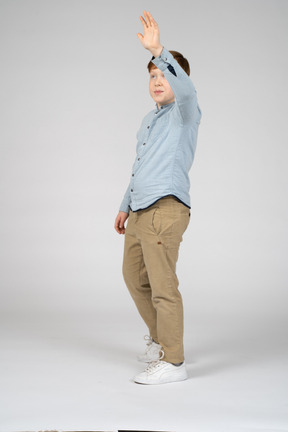 Side view of a cute boy waving