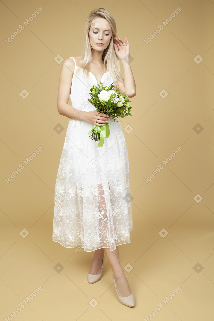 Beauitufl bride holding wedding bouquet and posing for a photo