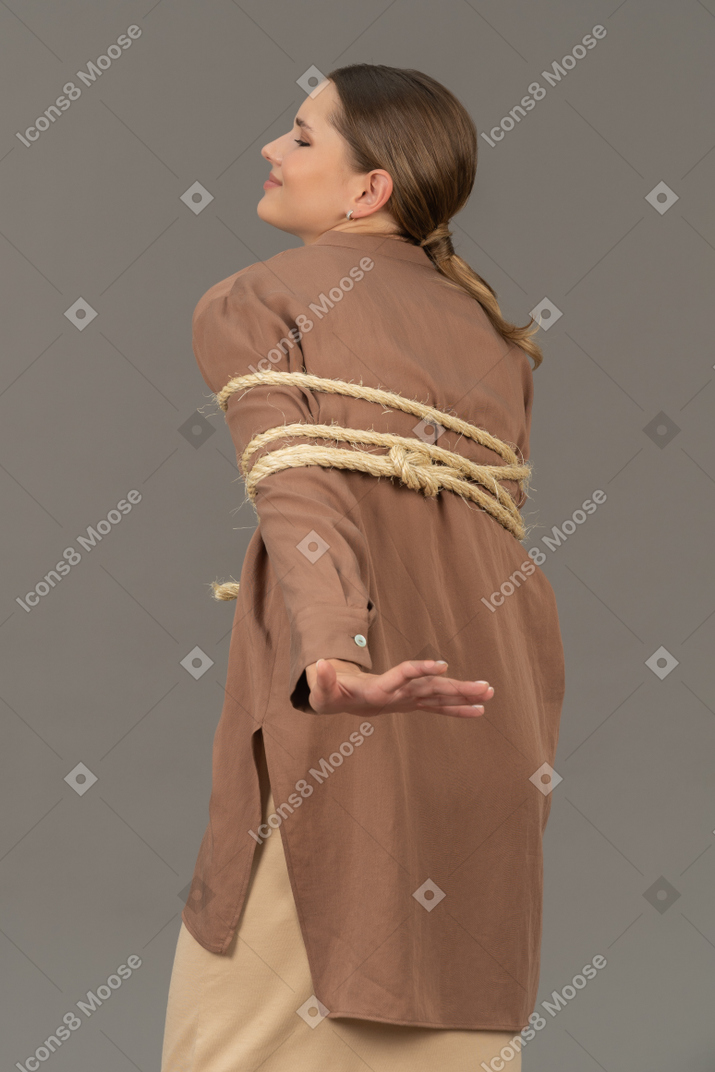 Back view of a young woman tied in rope