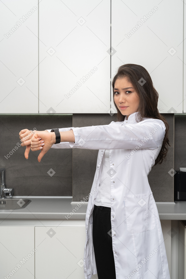 Close-up de uma médica mostrando gesto de antipatia com as duas mãos