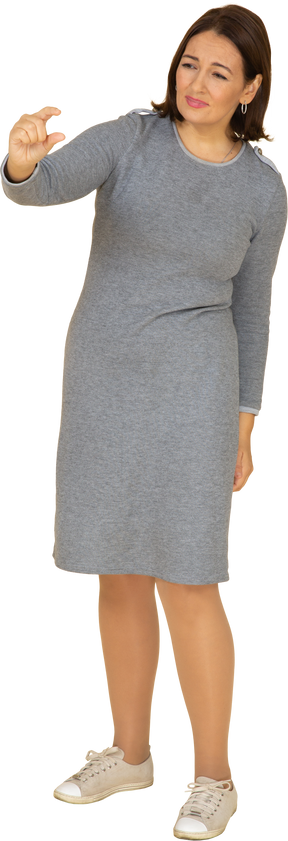 一个穿着灰色连衣裙的女人的前视图，显示出一个小尺寸的东西
