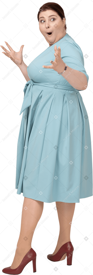 Вид сбоку впечатленной женщины в синем платье
