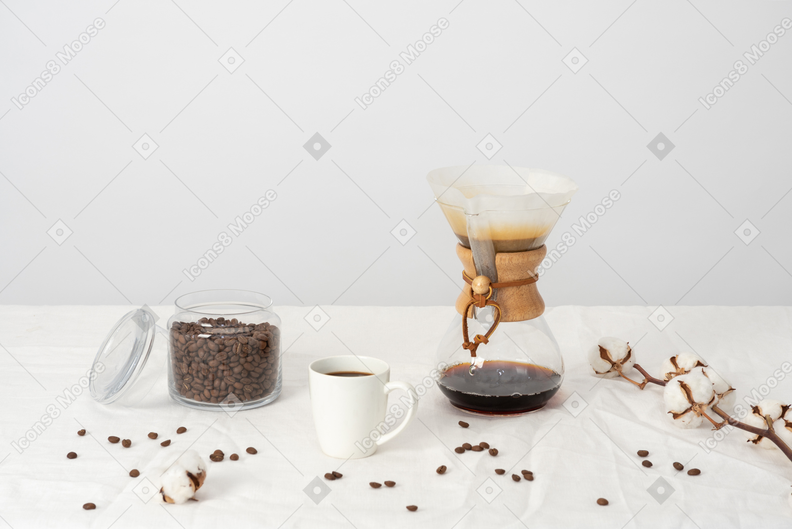 Chemex, large cup of coffee, jat of coffee beans, cotton branch and scattered coffee beans