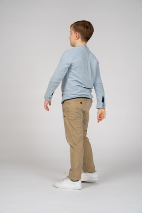 Boy in blue shirt and khaki pants walking
