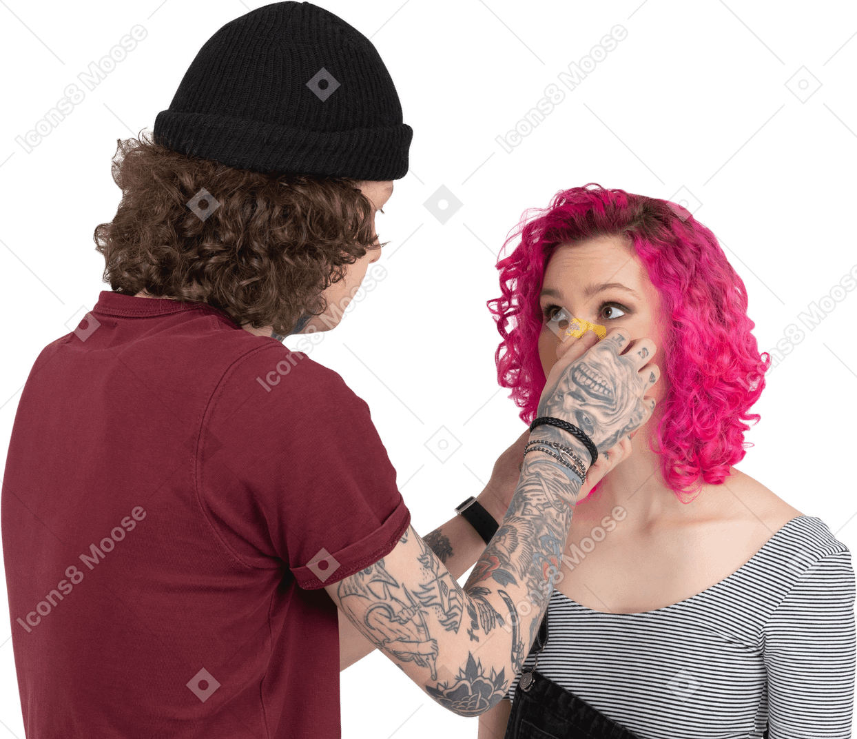 Jeune homme colle un plâtre jaune sur le nez de sa petite amie