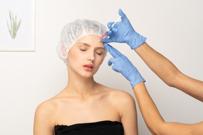 Young woman getting filler injection