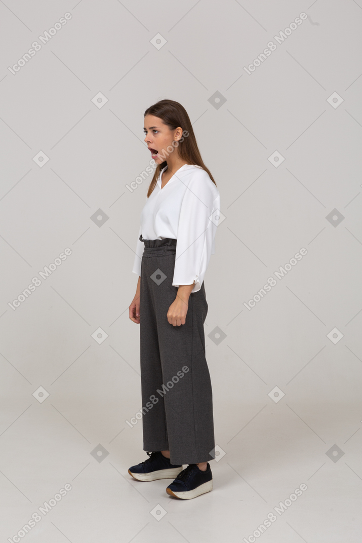 Three-quarter view of a young lady in office clothing standing with mouth wide open