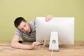 Hombre poniendo un cable de computadora en un zócalo