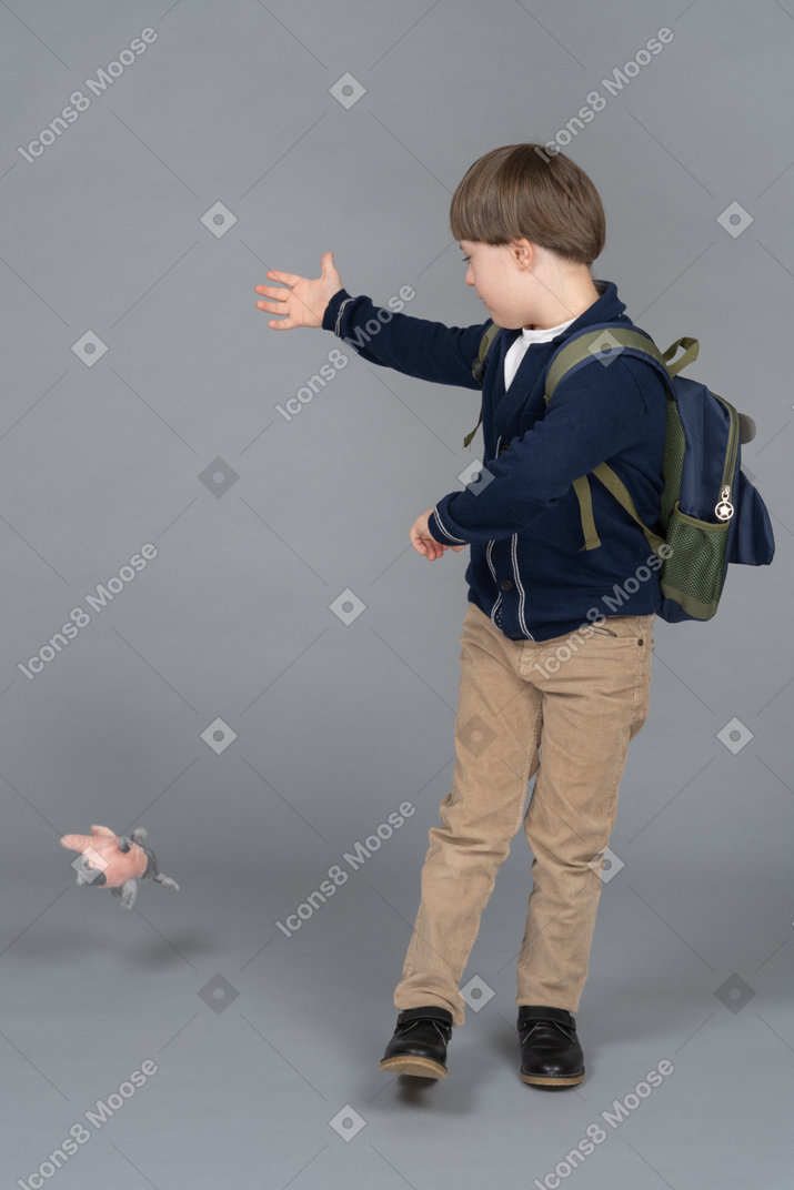 Schoolboy throwing away a plush toy