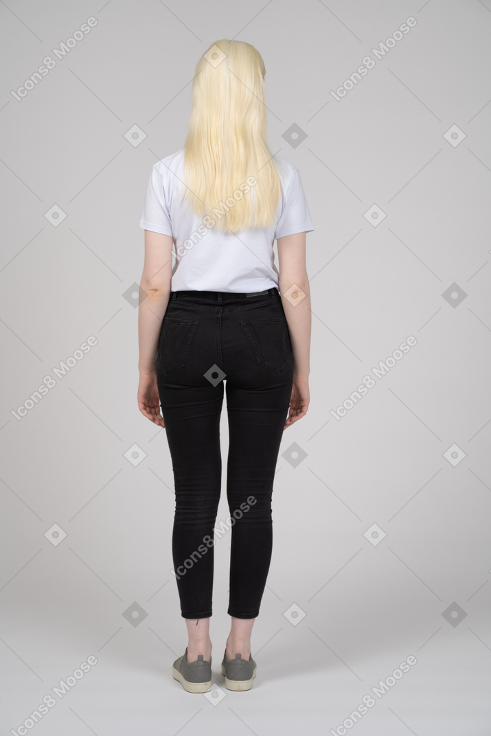Back view of teenage girl with arms at sides
