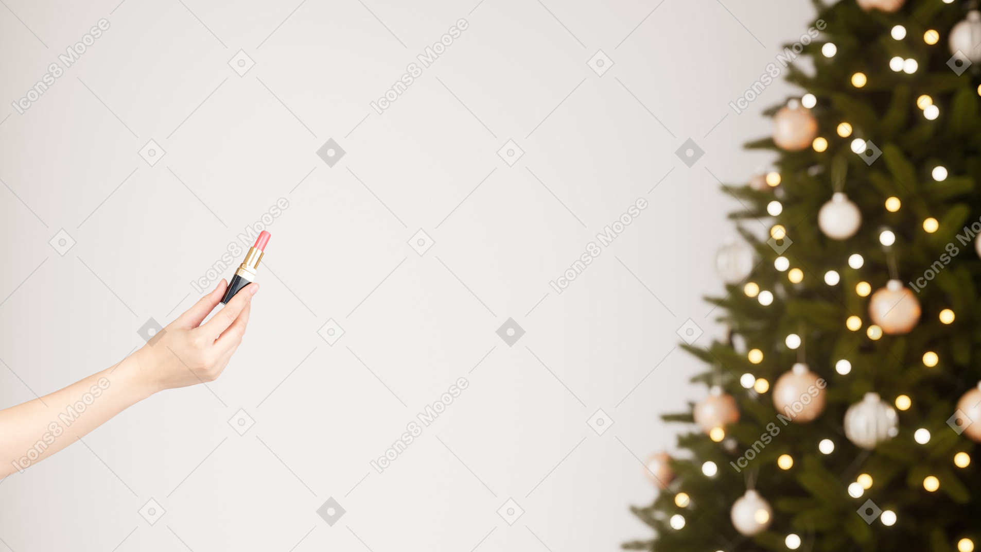 A woman holding a lipstick in front of a christmas tree
