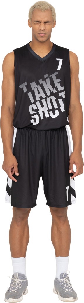 Vista frontal de um jovem jogador de basquete descontente com os olhos cerrados