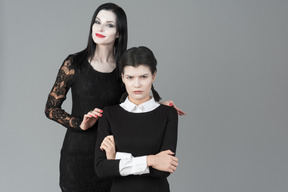 Morticia addams standing next to her daughter