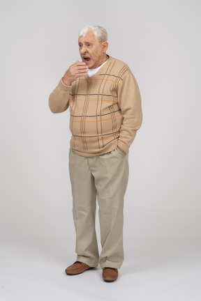 Vista frontal de um velho em roupas casuais bocejando