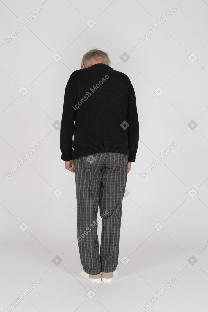 Vista traseira de um homem idoso em pé e olhando para baixo