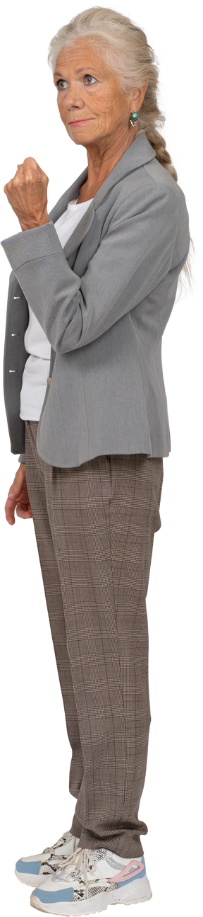 Side view of an old lady in suit showing fist