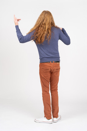 Rear view of a young man pointing up with a finger