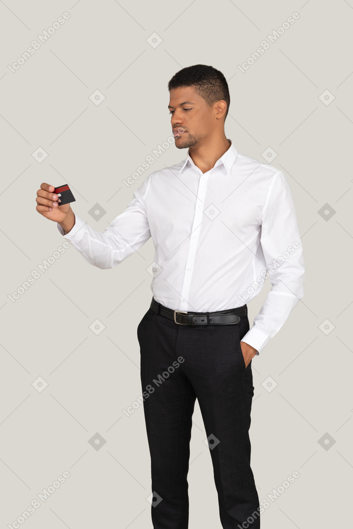 Мужчина смотрит на кредитную карту в руке