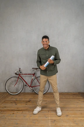 Front view of a man smiling wide holding a rolled up map