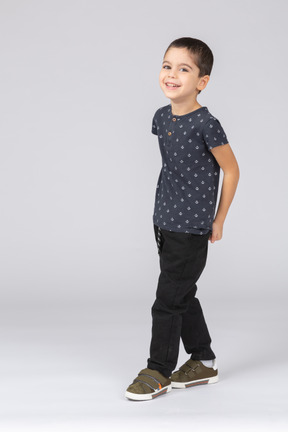 Vista frontal de um menino feliz em roupas casuais caminhando