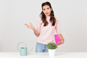 Attractive young woman taking care of a houseplant