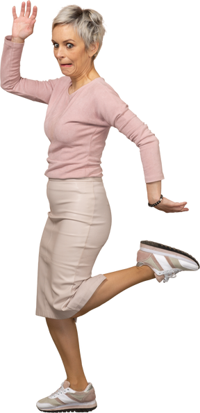 Side view of an emotional woman in casual clothes posing on one leg